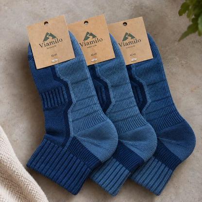 Drei Paar blaue Merino-Wandersocken von Viamilo mit Produktetiketten auf hellem Hintergrund